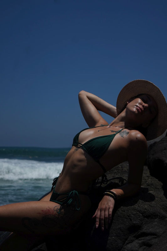 Model wearing Havana green triangle bikini set with adjustable ties at the beach