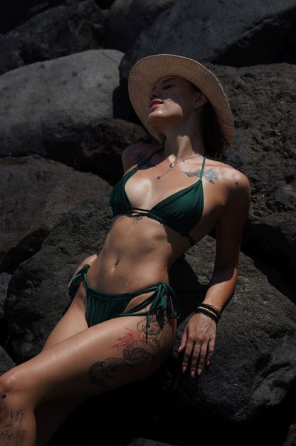 Model wearing Havana green triangle bikini set with adjustable ties at the beach